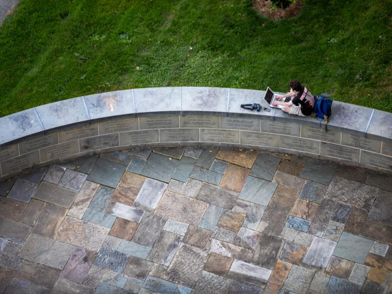 A student works at the base of McGraw Clocktower